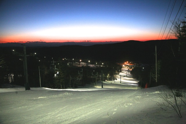 Bolton Valley under lights and the setting sun viewing the base area