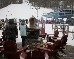 Outside the base lodge, skiers and tourists can enjoy the wood burning fire pit as skiers load on the Northwoods Gondola Outside the base lodge, skiers and tourists can enjoy the wood burning fire pit as skiers load on the Northwoods Gondola