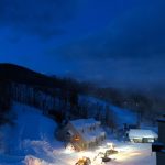 Snow Groomers working under moon over Loon Mountain. Snow Groomers working under moon
