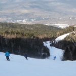 Skiers descending from summit of Loon Mountain in New Hampshires White Mountains Skiers descending from summit