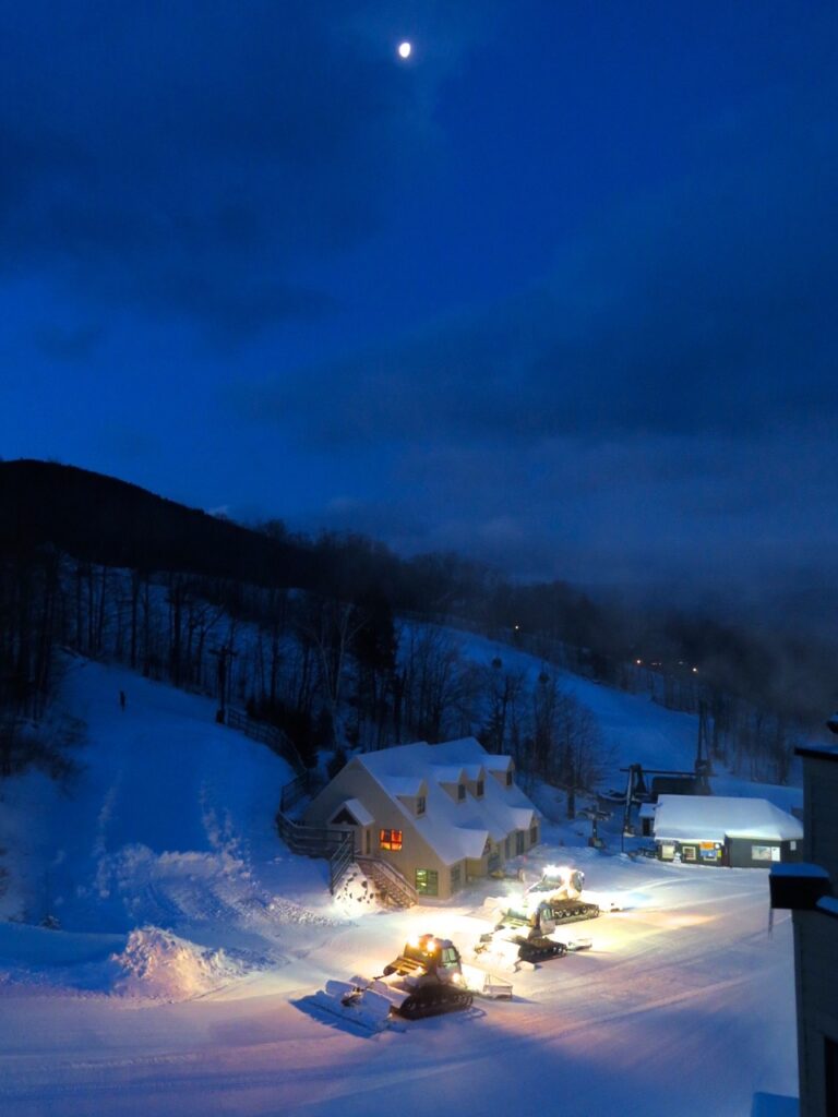 Snow Groomers working under moon