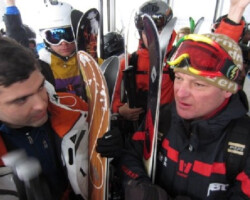 Austrian Mountain Guides talks with his clients aboard a cable car to discuss their next ski descent. Austrian Mountain Guides talks with his clients aboard a cable car to discuss their next ski descent.